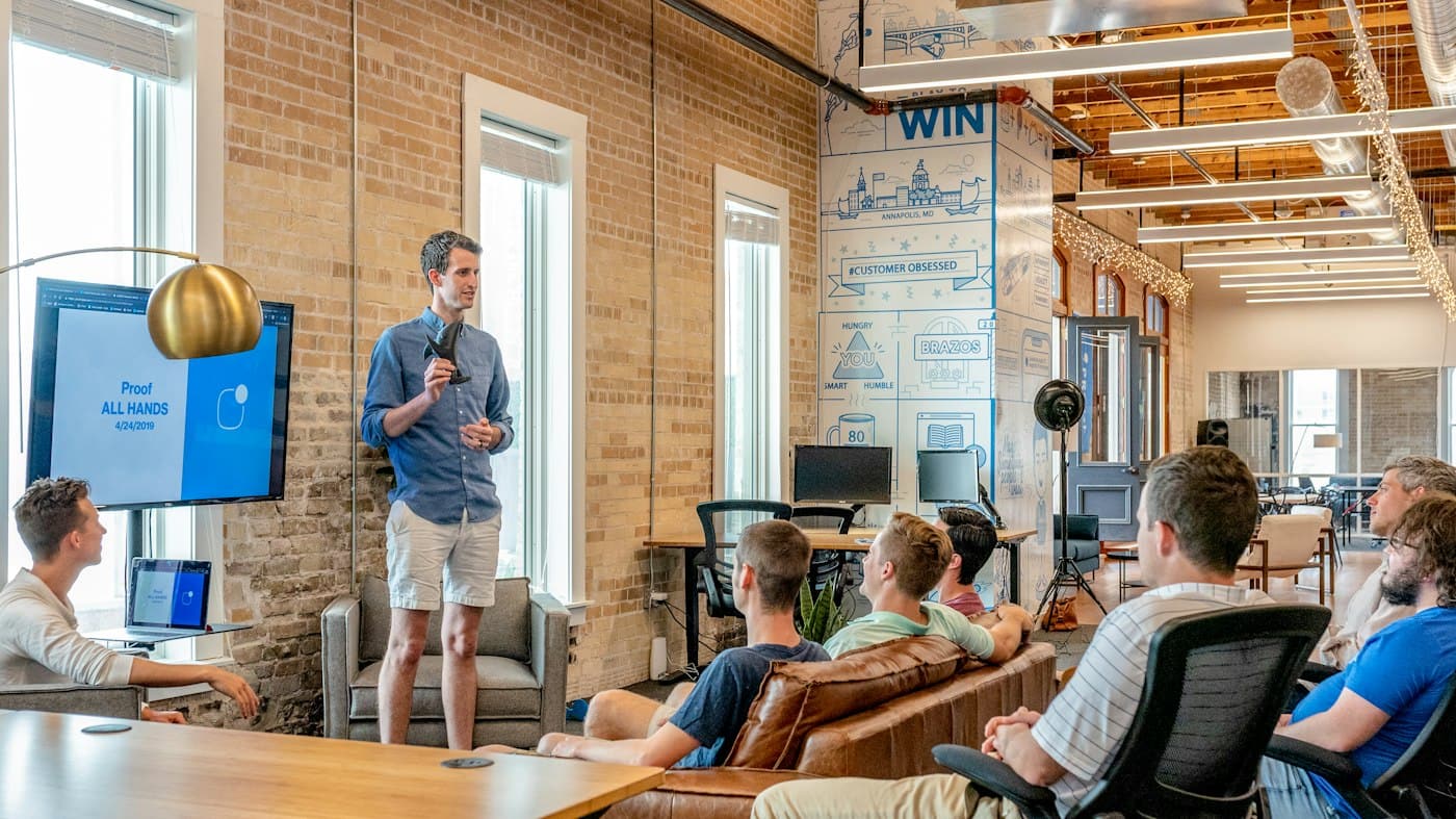 A founder presenting to a small group in an open-plan office