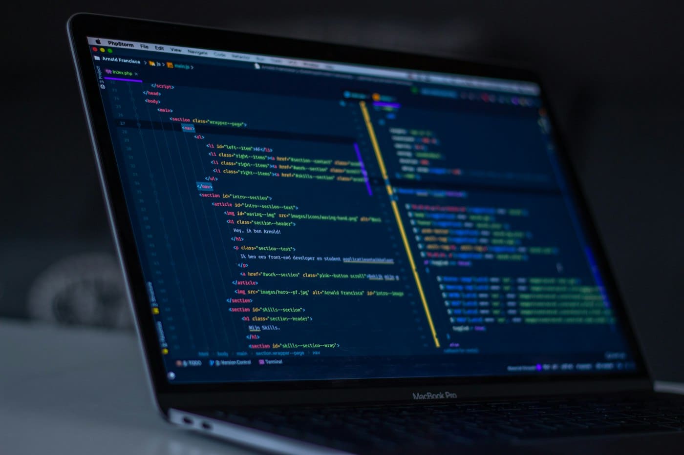 A laptop showing source code in a dark editor